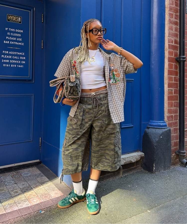Mulher usando camisa xadrez e bermuda com estampa camuflada