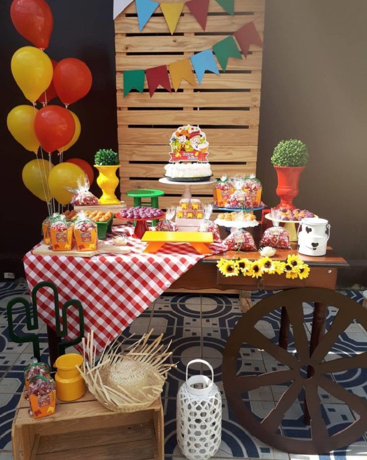 A imagem representa painel de pallet em decoração de festa caipira