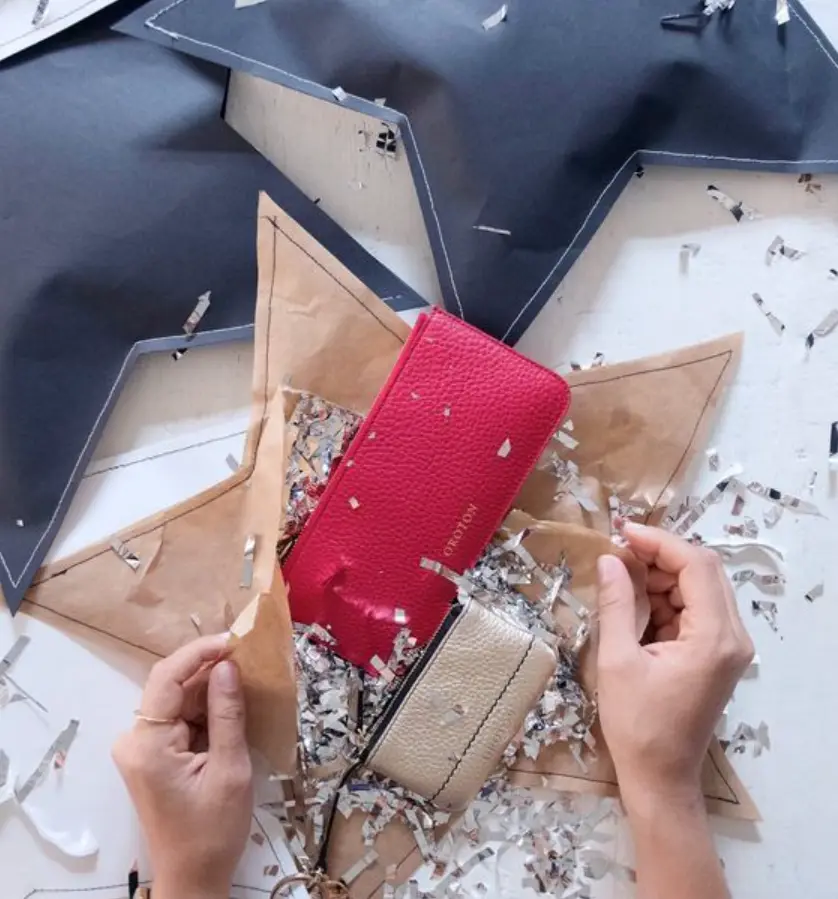 Embalagem de papel kraft em formato de estrela com confete dentro