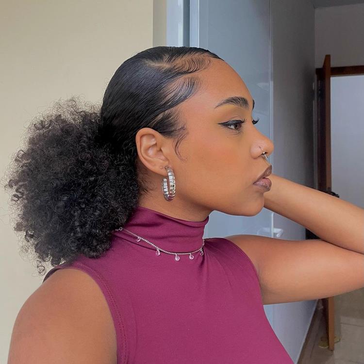 mulher de lado, cabelo cacheado preso em rabo de cavalo baixo