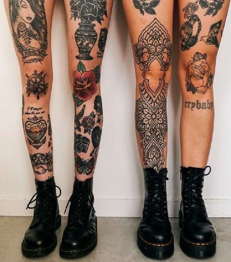 Foto de duas pessoas com pernas fechadas de tatuagens