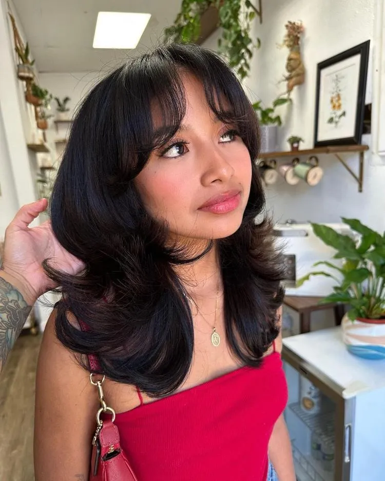 mulher de cabelo médio liso castanho e franja média