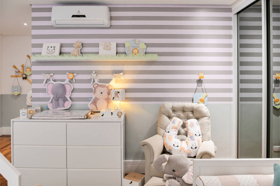 Quarto com parede listrada e decoração safári.