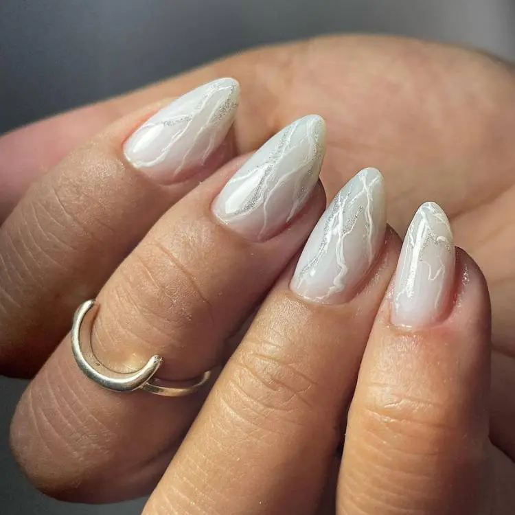 unhas almond com detalhes em branco e prata