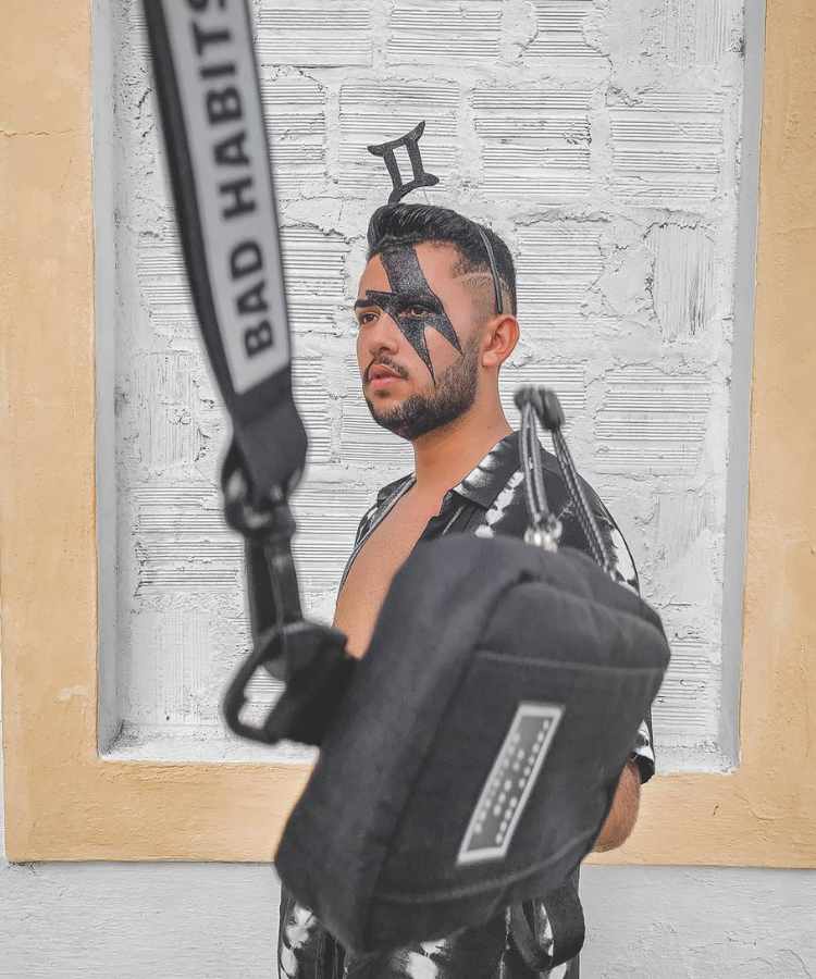 Homem de pele morena com maquiagem de raio preto no rosto para o Carnaval.