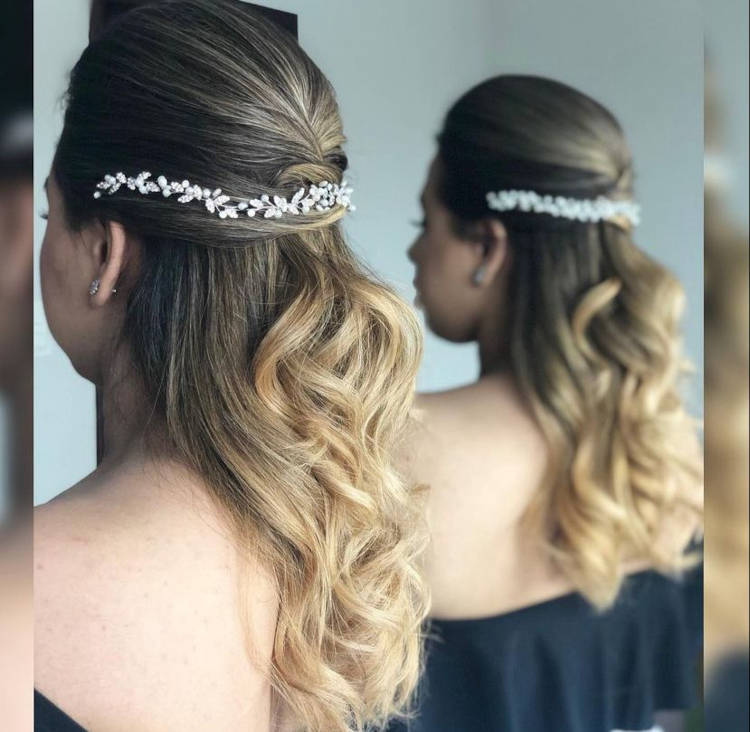 Mulher de pele clara com cabelo loiro semi preso com acessório