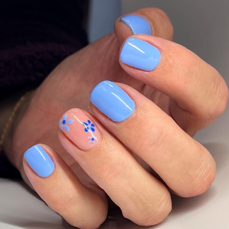 Unhas curtas em azul bebê e filha única em nude com flores
