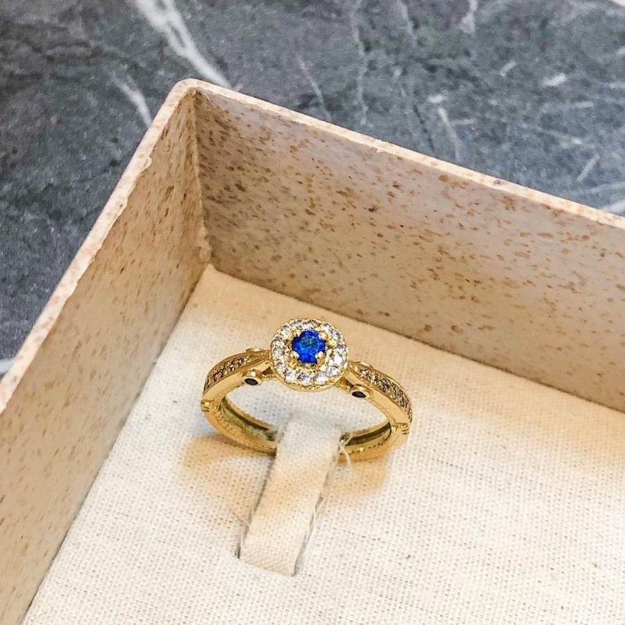 Anel de formatura psicologia com pedra safira azul dentro de caixa bege