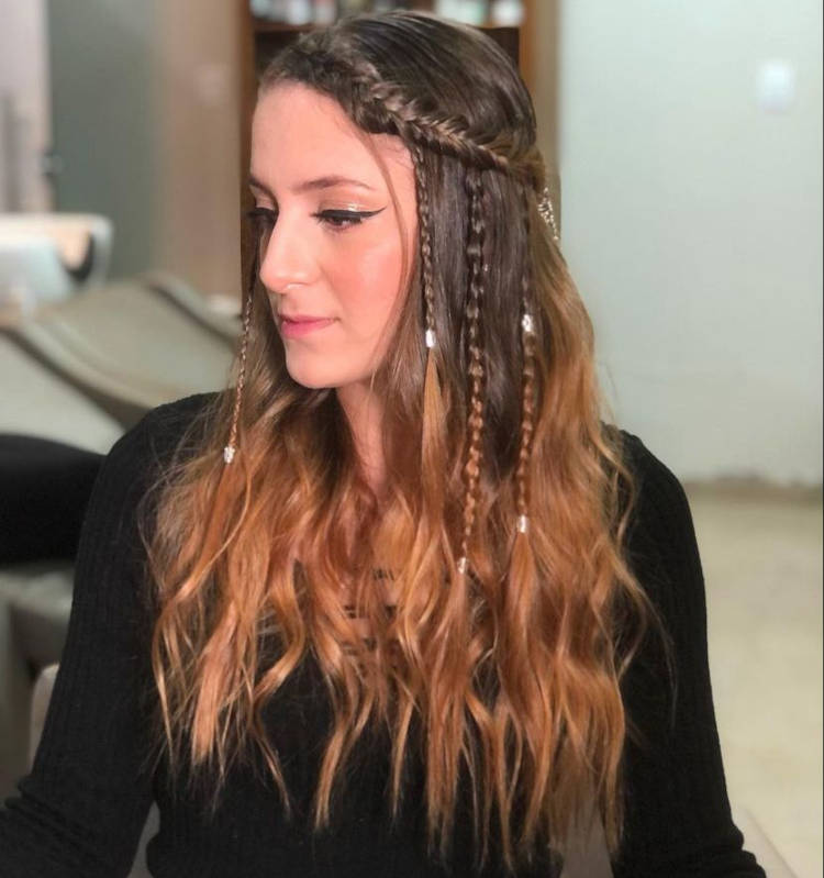 Mulher de pele clara com cabelo castanho solto com mini tranças
