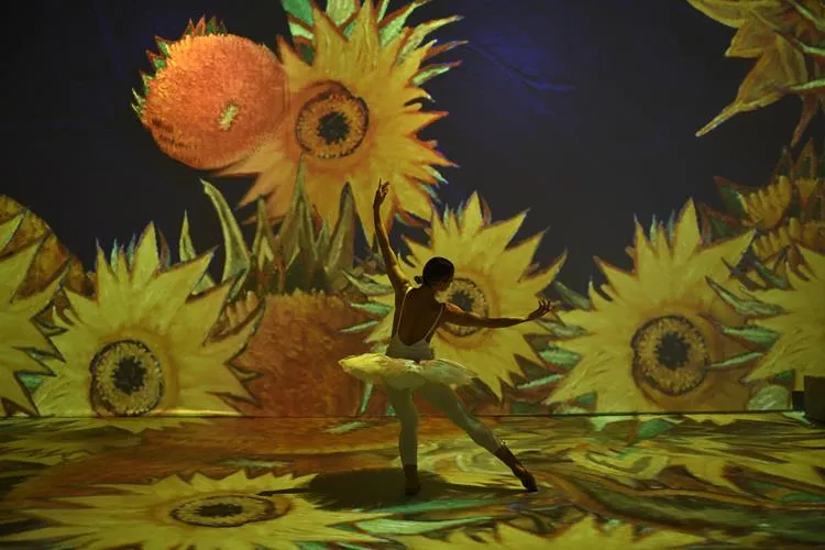 exposição van gogh, fundo imersivo de girassóis com bailarina na frente