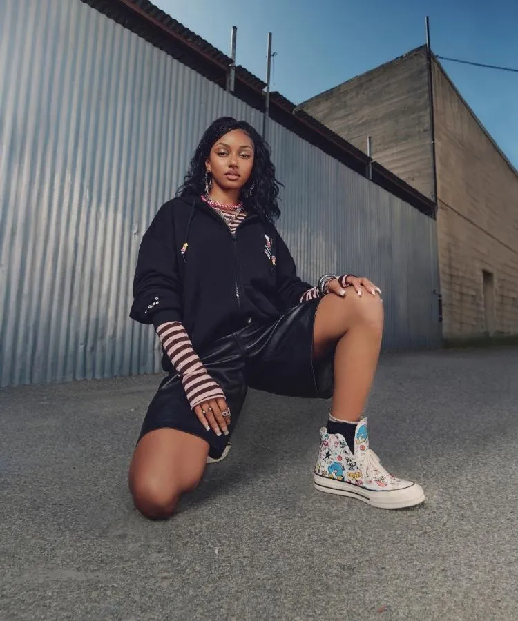 Foto de modelo negra usando casaco e tênis da collab Converse x Hello Kitty® And Friends