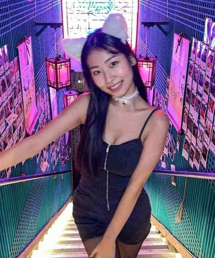 Mulher asiática com look preto e tira branca de orelha de gato peluda