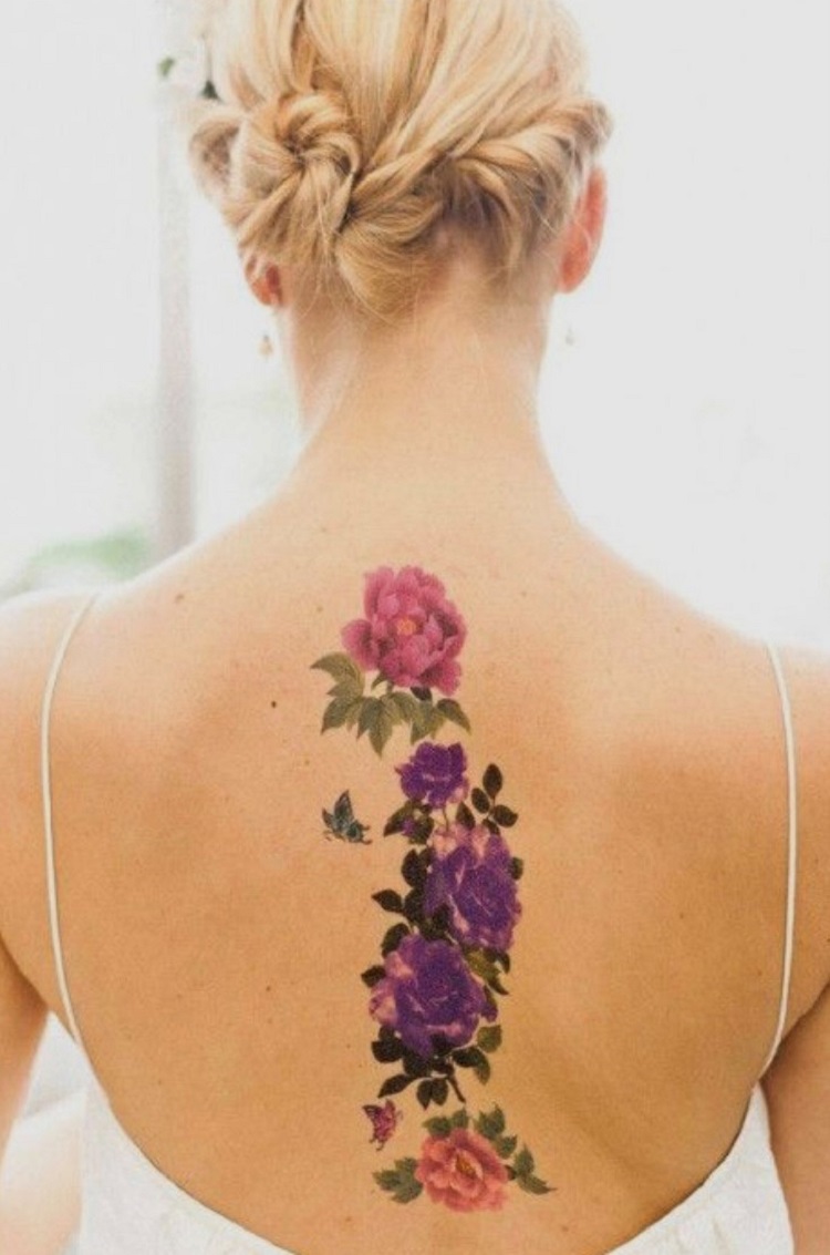 Tatuagem de flores rosas e roxas nas costas