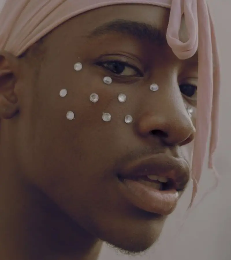 Homem de pele negra com strass no rosto