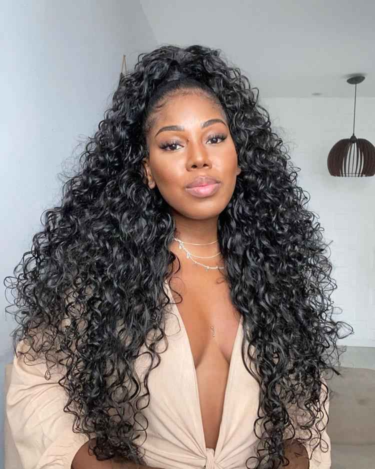 mulher de pele morena com cabelo preto cacheado meio preso alto