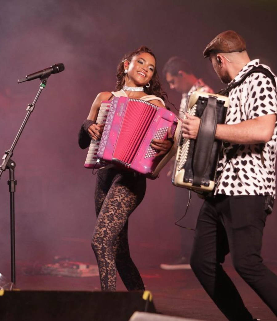 Lucy Alves fazendo show e tocando uma sanfona com o Rodrigo Ferrero