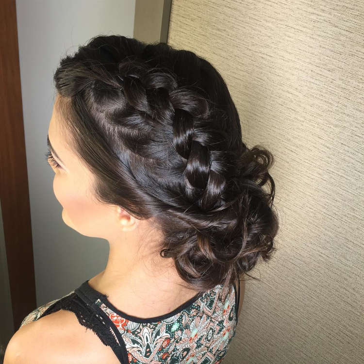 Mulher com cabelo curto preto e trança lateral finalizada em coque