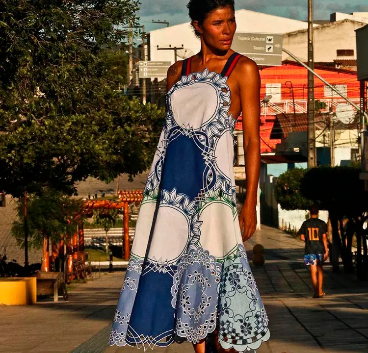 Modelo com Vestido longo azul e branco.