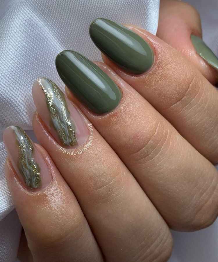 Pessoa de pele clara com unha redonda verde e anelar decorado com dourado e faixa estilo marmorizado