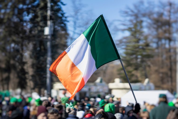 Multidão ao fundo com bandeira da Irlanda em destaque