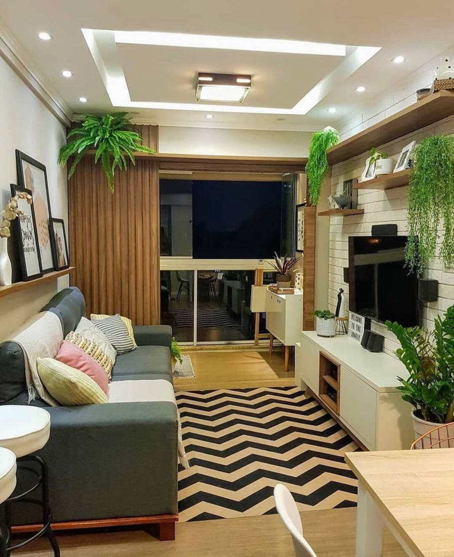 Sala decorada com plantas, tapete e almofadas coloridas.