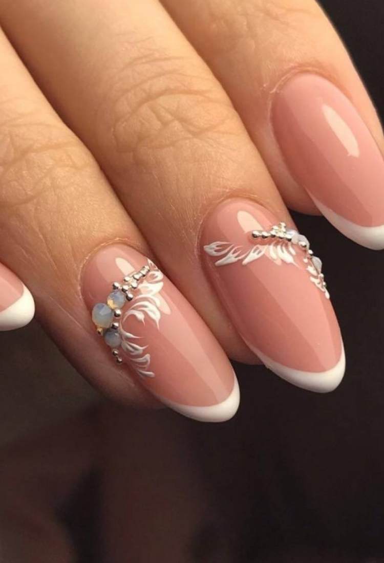 Unhas ovais nudes com flores e pedrarias
