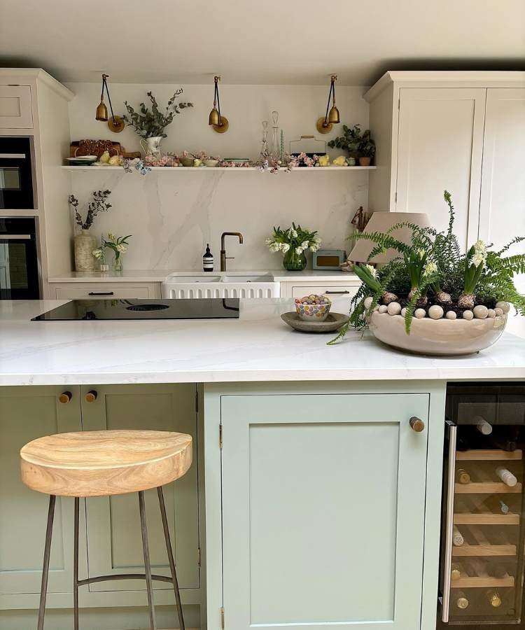 Cozinha americana com um vaso de cerâmica com plantas diversas, incluindo a samambaia