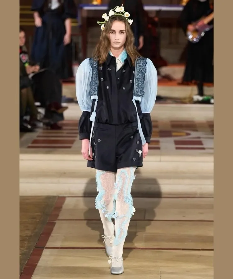 Foto de modelo usando look com meia-calça diferente, uma das tendências da London Fashion Week Outono Inverno 2026