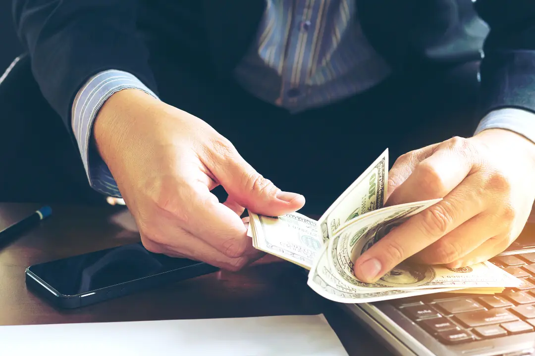 Imagem de um homem de negócios contando notas de dólar para compra seu Jet Ski Imagem de um homem de negócios contando notas de dólar para compra seu Jet Ski.
