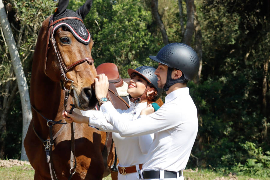 Casal acariciando um cavalo.