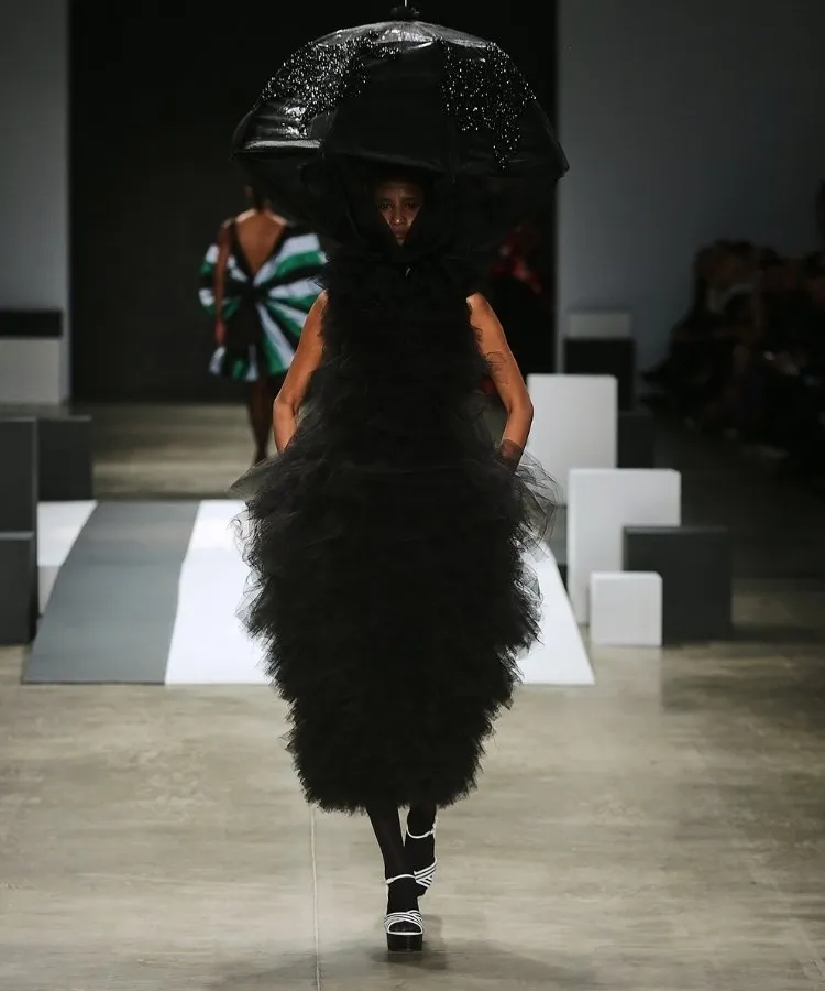 Foto de modelo na passarela usando vestido longo preto