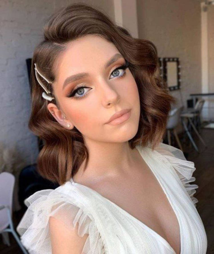 Mulher de pele clara usando cabelo curto ondulado com presilha