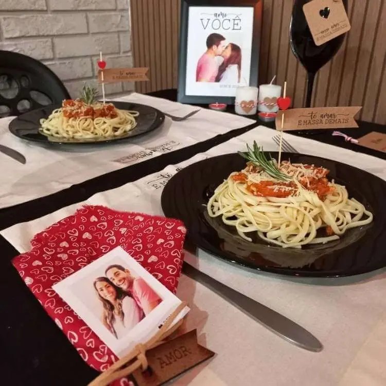 Mesa posta com macarrão no prato e foto do casal como decoração