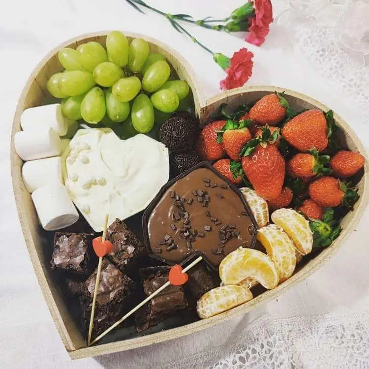 Cesta em formato de coração com frutas e doces