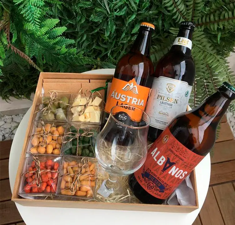 Cesta com petiscos, um copo e 3 cervejas artesanais
