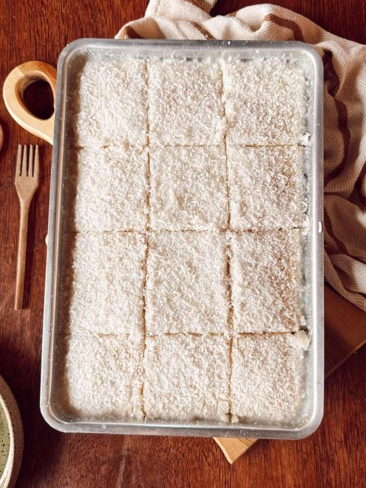 Travessa retangular com bolo gelado de coco cortado 