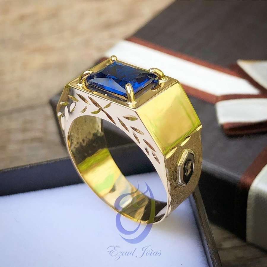 Anel dourado grosso com pedra azul retangular