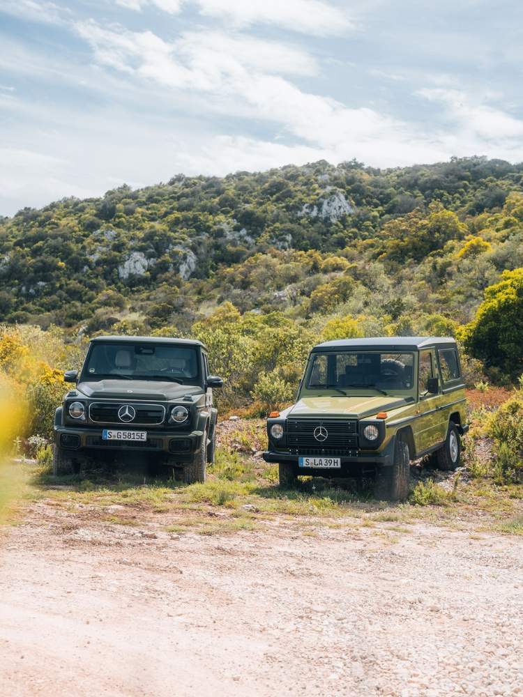 Duas Mercedes Classe G, uma preta e outra verde musgo, em meio à vegetação