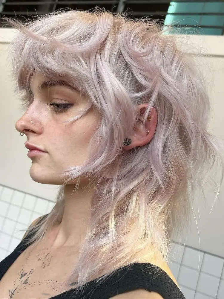 Mulher de pele clara com cabelo lilás em fairy cut 