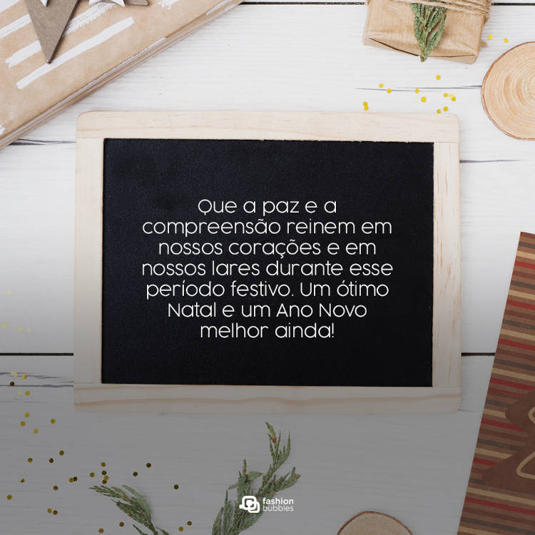 Mesa clara com quadro escrito: Que a paz e a compreensão reinem em nossos corações e em nossos lares durante esse período festivo. Um ótimo Natal e um Ano Novo melhor ainda!