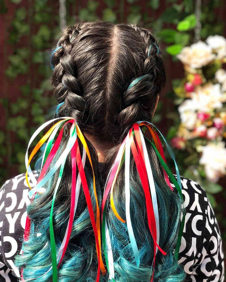 Cabelo preto com mechas azuis,  trançado com fitas coloridas.