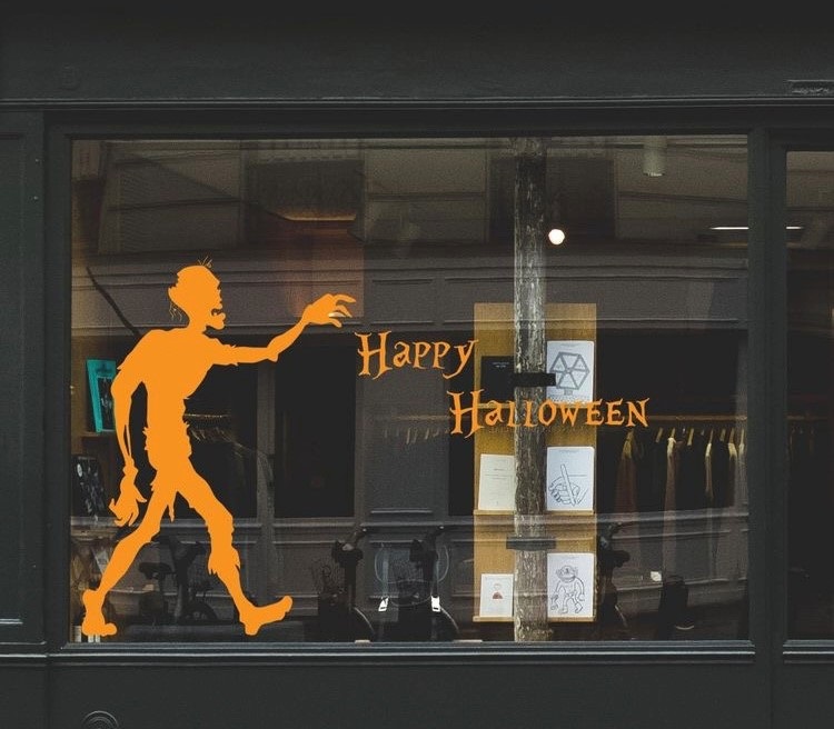 Vitrine escrito Happy Halloween em laranja e desenho de zumbi também laranja 