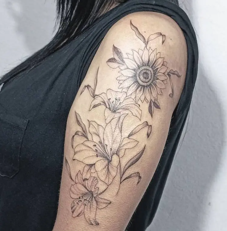 Tatuagem grande de lírios e girassol no braço em fineline