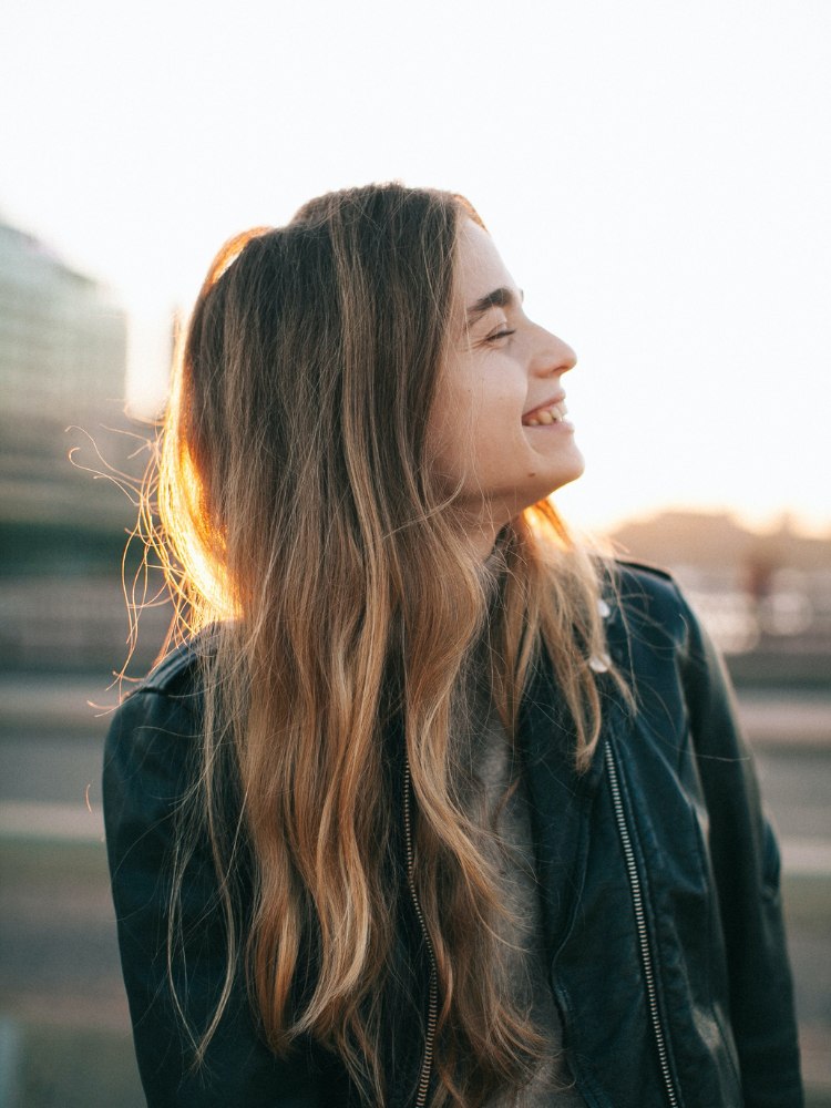 Mulher loira sorrindo para post sobre legendas para fotos sorrindo