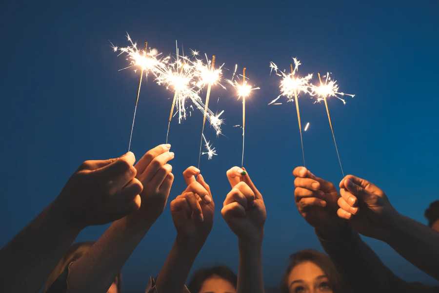 Pessoas segurando velas no Ano Novo.