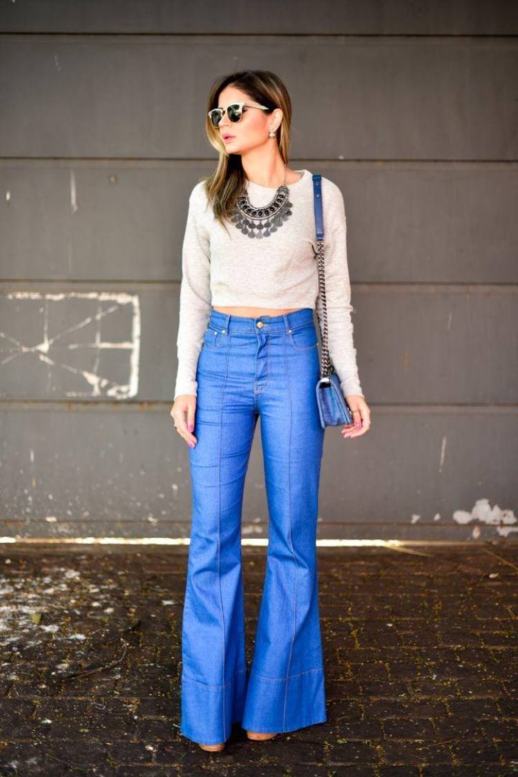 Thássia Naves usando cropped bege manga longa, maxi colar, calça jeans flare