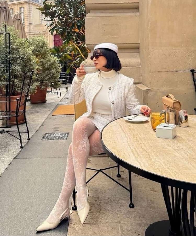 Mulher usando look com meia-calça de renda branca
