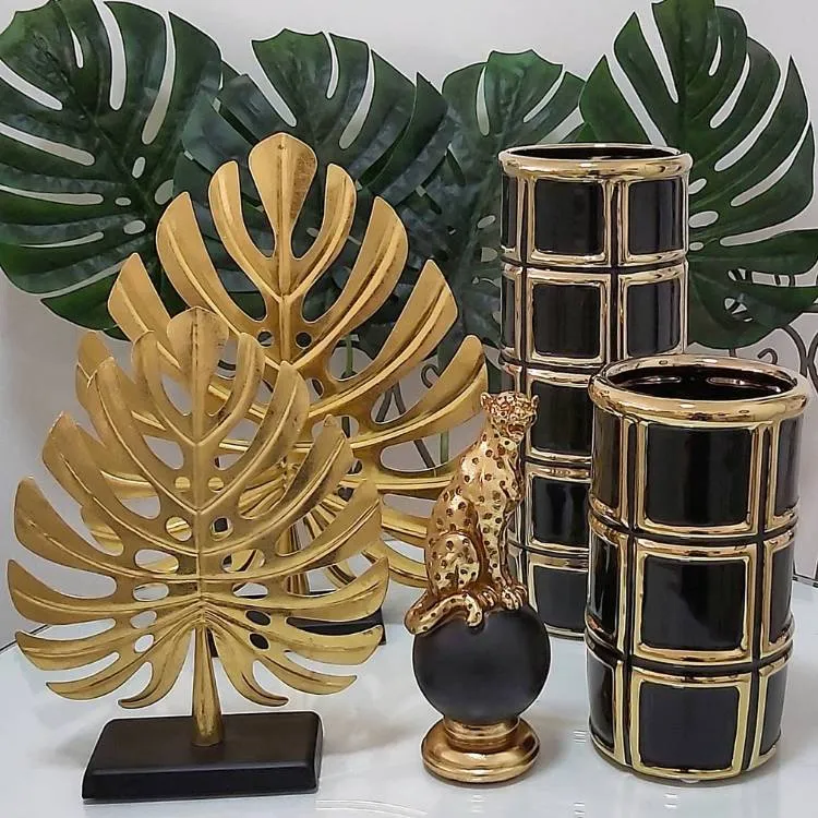 Decorações em formato de folha de Monstera de diferentes tamanhos em dourado e em verde.