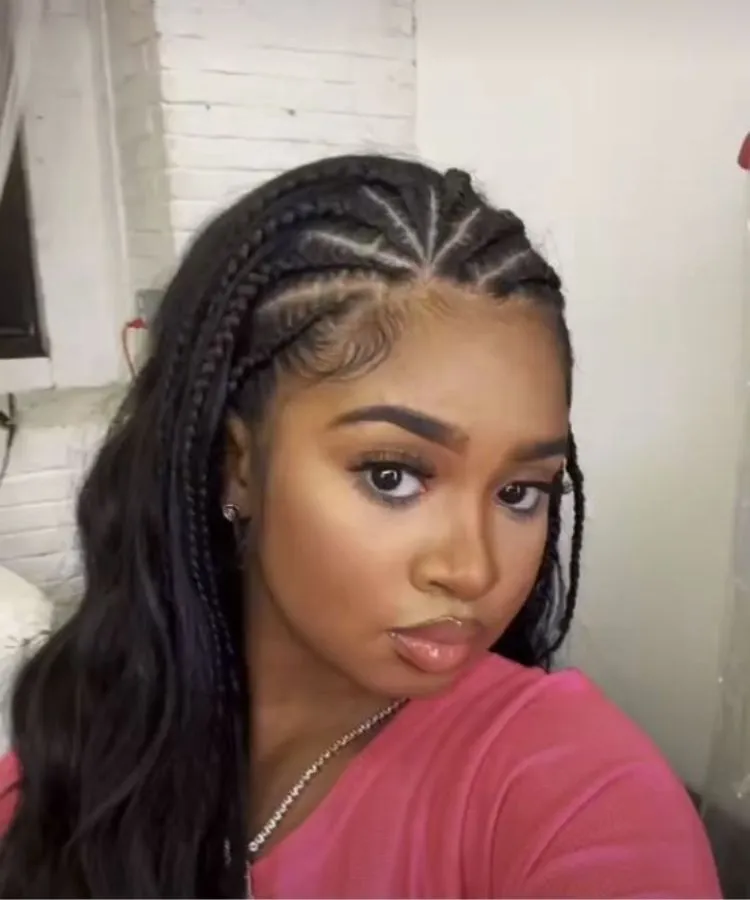 Menina com trança nagô no cabelo liso. Ela usa camiseta rosa