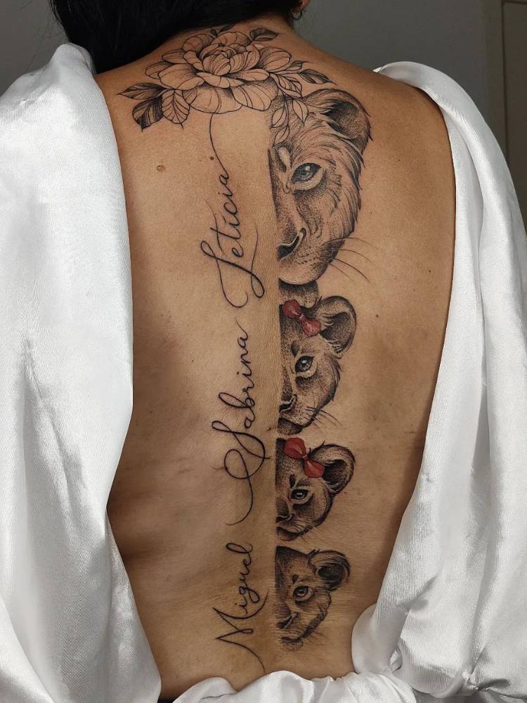 Costas de mulher de pele clara com tatuagem de loba com filhotes e nome dos filhos